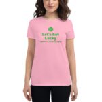 A person is wearing a pink t-shirt with green text that says Let's Get Lucky and Happy St. Patrick's Day along with a green clover symbol  suggesting a festive atmosphere.