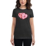 A woman wearing a black t-shirt stands confidently showcasing a graphic of two overlapping hearts filled with various sweets in pink and red against a dark background.