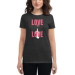 A woman wears a dark t-shirt featuring the word "LOVE" in various colors and fonts  standing in a neutral setting  conveying a positive and inclusive message.