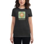 A woman wearing a dark t-shirt stands smiling showing a graphic featuring a green and orange design with the text HAPPY ST PATRICK'S DAY above a shamrock.