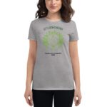 A gray t-shirt displays the text LET'S GROW TOGETHER in green above an illustration of the Earth surrounded by hands and leaves with the text HAPPY ST. PATRICKS 2024 below
