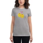 A woman is wearing a gray t-shirt featuring two cartoon olives with smiling faces and the text OLIVE YOU above them  standing against a neutral background.