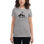A woman stands wearing a gray t-shirt featuring a graphic of two birds on a branch with leaves and hearts above them along with the text Spring in the air.