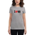 A woman wears a gray t-shirt featuring the word Love in large black letters with a red heart symbol integrated into the design  posing against a neutral background.