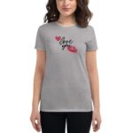 A woman wears a gray t-shirt featuring red lips and the phrase love you in a playful font  showing her smiling expression against a neutral background.