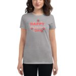 A woman is wearing a light gray t-shirt featuring colorful text that reads HAPPY VALENTINE'S DAY surrounded by floral graphics  set against a neutral background.