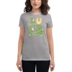 A woman wears a grey t-shirt featuring the word "LUCK" with a horseshoe and shamrocks celebrating St. Patrick's Day against a neutral backdrop.