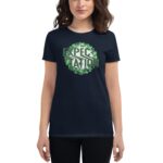 A person wearing a navy t-shirt displays the word "EXPECTATION" surrounded by green clovers  symbolizing a festive or positive theme in an informal setting.