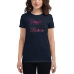 A person is wearing a black t-shirt with the text “Hugs & Kisses” displayed in pink and white letters  suggesting a casual  affectionate theme in a neutral setting.