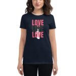 A navy t-shirt features the word "LOVE" repeated in varying sizes and colors  worn by a woman with shoulder-length hair against a neutral background.