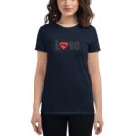 A woman is wearing a dark blue t-shirt featuring the word "Love" in brown with a red heart design and hands inside the heart against a plain background.