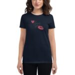A woman wears a navy t-shirt featuring pink lips and heart graphics with the text "love you" displayed prominently  set against a simple white background.