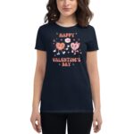 A woman wears a dark t-shirt featuring playful cartoon hearts celebrating Valentine’s Day with the text "HAPPY VALENTINE'S DAY" surrounded by stars and hearts in a festive setting.