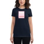 A woman wearing a navy blue t-shirt features a graphic of a stamp with the text XOXO in various colors arranged in a square pattern on the chest area.