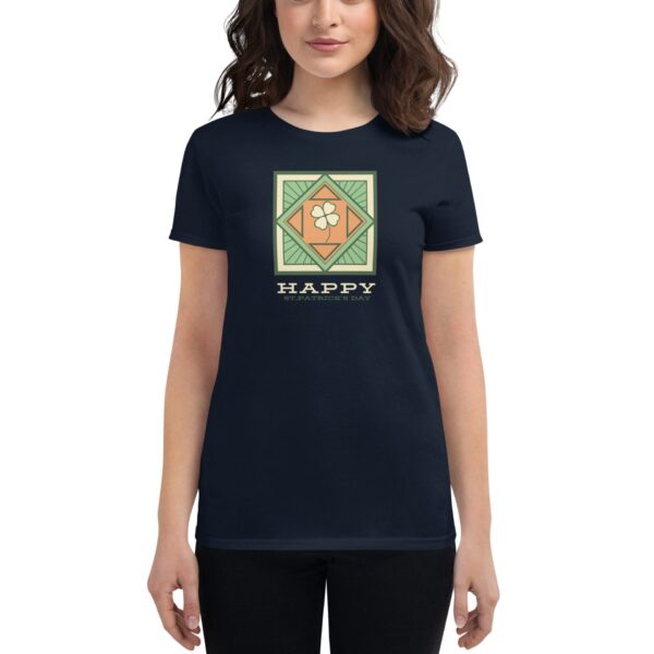 A woman wears a navy t-shirt displaying a green and orange graphic featuring a shamrock and the text HAPPY ST PATRICK'S DAY in a festive design.
