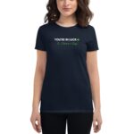 A woman stands wearing a dark t-shirt that displays the text YOU'RE IN LUCK St. Patrick's Day along with a green shamrock symbol emphasizing a festive mood.