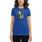A woman stands wearing a blue t-shirt featuring an illustration of a bearded figure in a green robe holding a staff with the word LUCKY beneath surrounded by small decorations.