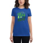 A woman wears a blue t-shirt featuring the text "TAKE IT EASY" in green playful letters  with small illustrations and stars surrounding the text  conveying a relaxed vibe.