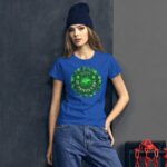 A young woman wears a blue t-shirt featuring a green St. Patrick's Day design with shamrocks while leaning against a gray wall with a red chain beside her.