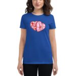 A woman is wearing a blue t-shirt featuring a graphic of two overlapping heart shapes filled with various confections  standing against a light background.