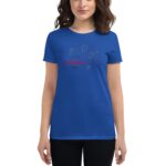 A blue t-shirt features the text "Happy Valentine's Day" in a playful font surrounded by heart shapes  worn by a woman with shoulder-length hair in a neutral setting.