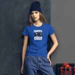 A young woman stands against a textured gray wall wearing a bright blue t-shirt with the text "HAPPY LOVE DAY" and a beanie  complemented by casual denim jeans.