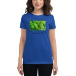 A person wears a bright blue t-shirt featuring a green image of clovers with text that reads "FEELIN' LUCKY HAPPY ST.PATRICK'S DAY" in a casual setting.