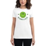A woman wears a white t-shirt featuring a large green smiley face and the text HAPPY FACE in a playful font. She stands confidently against a plain background.