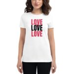 A woman wears a white t-shirt featuring the repeated word "LOVE" in red and black text against a neutral background  expressing a message of affection and positivity.