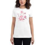 A woman stands wearing a white t-shirt featuring floral designs and the word "LOVE" prominently displayed in the center  suggesting a casual and cheerful style.