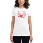 A woman wears a white t-shirt featuring a colorful graphic of two gnomes holding a red heart with the text A love like gnome other Love above them.