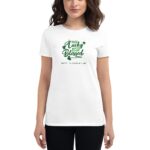 A woman is wearing a white shirt with green text that reads not lucky just blessed and Happy St. Patrick's Day alongside shamrock graphics in a casual setting.