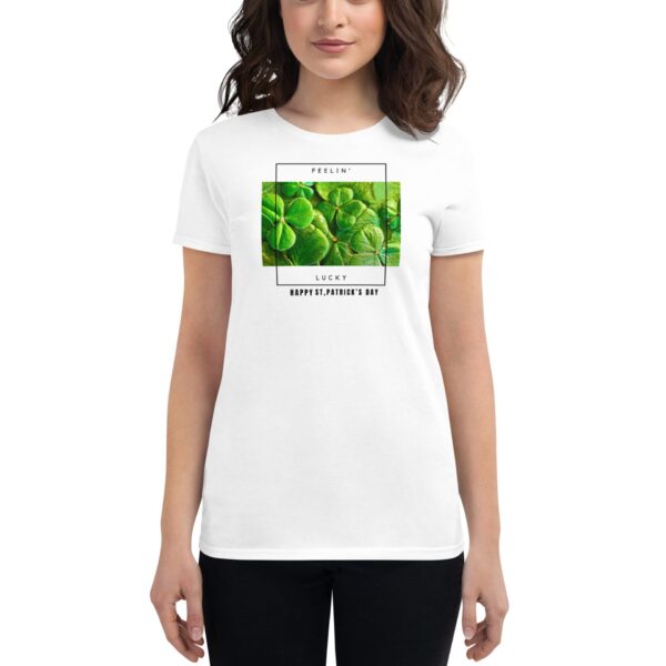 A person wears a white t-shirt with a graphic of green clovers and text that says "FEELIN' LUCKY HAPPY ST.PATRICK'S DAY" suggesting a celebration of St. Patrick's Day.