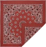 A red bandana featuring intricate white paisley patterns and designs laid out flat with one corner folded over creating a decorative display against a neutral background