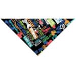 A triangular fabric features colorful text and paw prints with words like "good dog" "love" and "woof" scattered across a black background  creating a playful design for pet accessories.