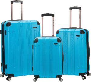 Three blue suitcases of varying sizes are arranged next to each other with retractable handles extended  set against a plain background  showcasing their hard shell design and rolling wheels.
