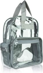 A transparent backpack features multiple compartments with gray fabric accents it stands upright showcasing its spacious interior suitable for various items in a clean environment.