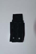 A black fabric pouch with two button closures is displayed flat. It likely holds tools or equipment and is set against a plain white background.