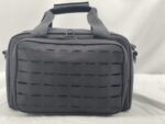 A black bag with a textured surface featuring rectangular cutouts sits on a light background emphasizing its sleek design and practicality for storage and transport.