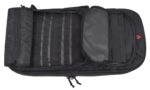 A black tactical backpack lies open displaying a grid of vertical straps for attachment purposes alongside a smooth compartment on the right side designed for storage or organization.