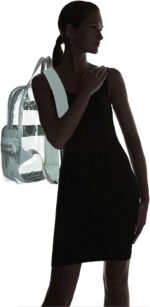 A woman in a black dress stands with a transparent backpack on her shoulder highlighting her silhouette against a light background while she gently touches her shoulder with one hand