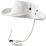 A white bucket hat hangs in mid-air showcasing its wide brim and two metal eyelets on either side with a chin strap attached for securing it in place.