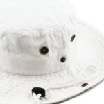 A white bucket hat is positioned upright with a textured surface featuring metal ventilation holes and a cord for adjustment around the brim in a neutral background.