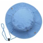 A light blue bucket hat sits flat with a round crown and a wide brim the hat features a rope strap and has golden eyelets on the side for ventilation.