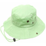 A light green bucket hat rests flat with a wide brim featuring metal ventilation grommets and an adjustable chin strap  suggesting its use in sunny or outdoor settings.