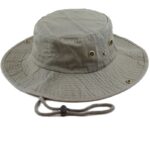 A wide-brimmed bucket hat with a soft fabric texture features brass eyelets and a rope chin strap designed for outdoor protection from sun and rain in casual environments.