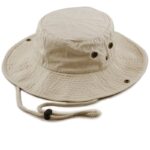 A light beige bucket hat rests flat with a rounded top and wide brim featuring ventilation holes and a drawstring for secure fitting often used for sun protection during outdoor activities.