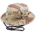 A camouflage bucket hat rests on a surface featuring a wide brim and adjustable chin strap showcasing a mix of tan and brown patterns ideal for outdoor activities.