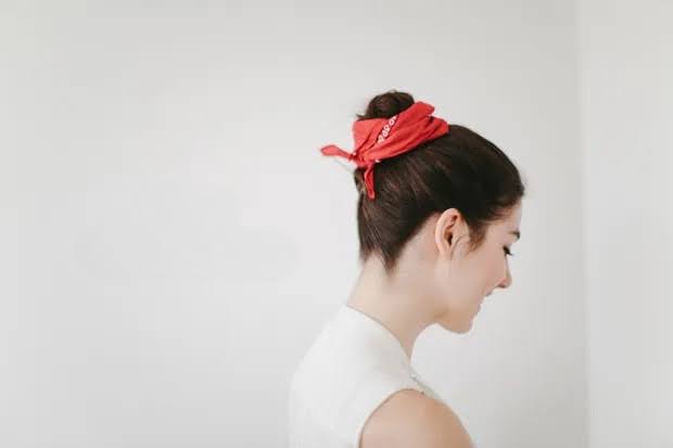 a woman with a red scarf in her hair