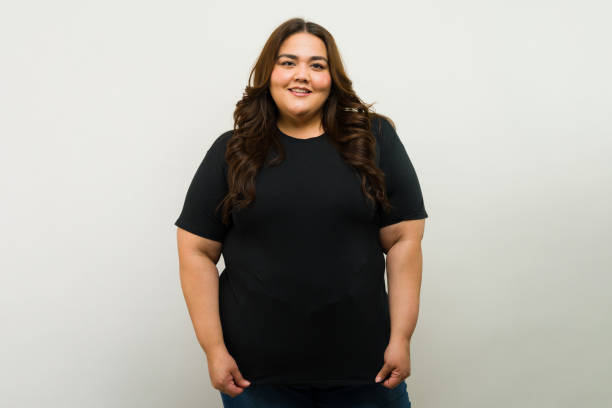 Plus-size woman wearing a fitted T-shirt that contours her curves, styled to enhance shape with a flattering neckline and confident posture.